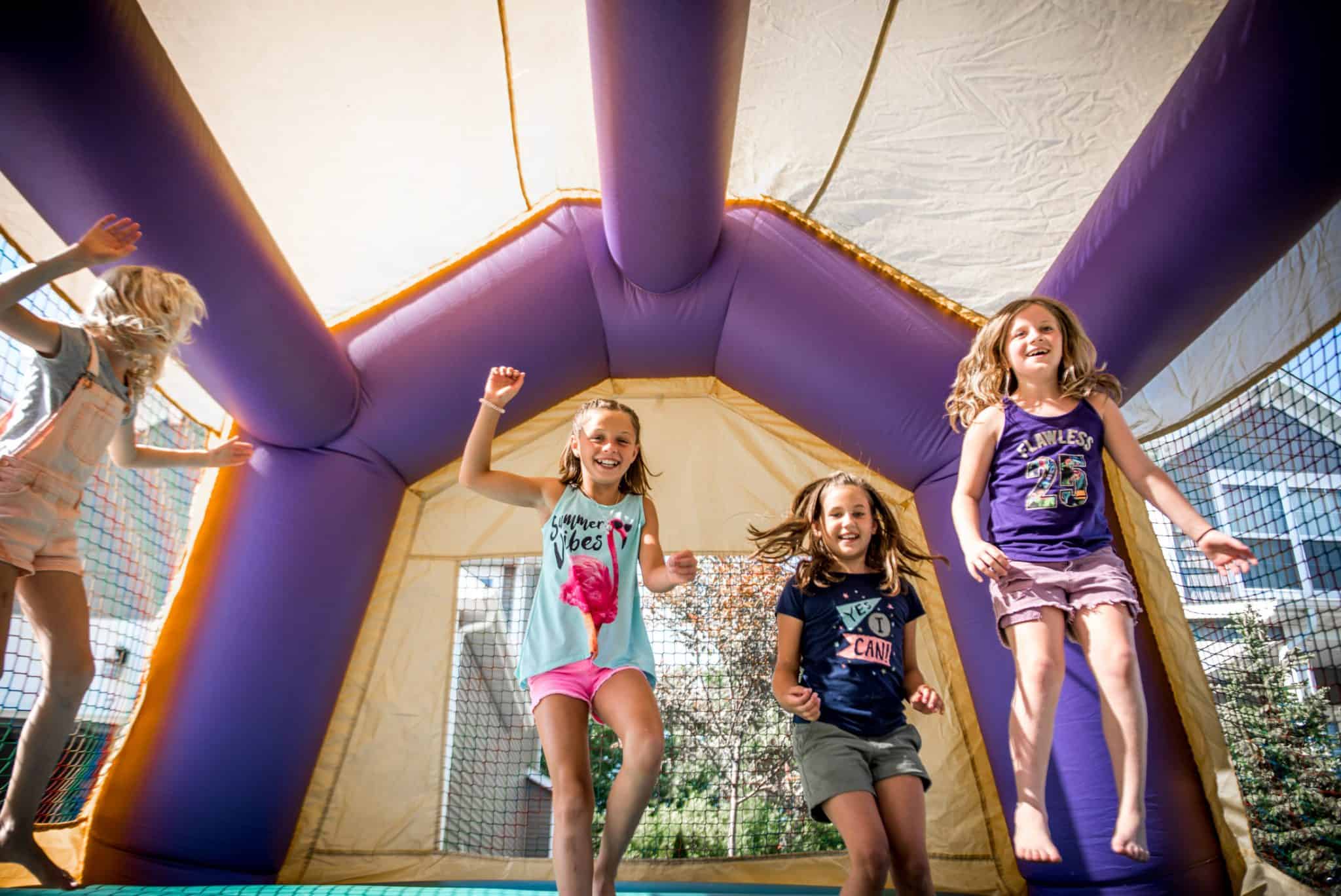 The Apex kiddos jumping in the bouncy house