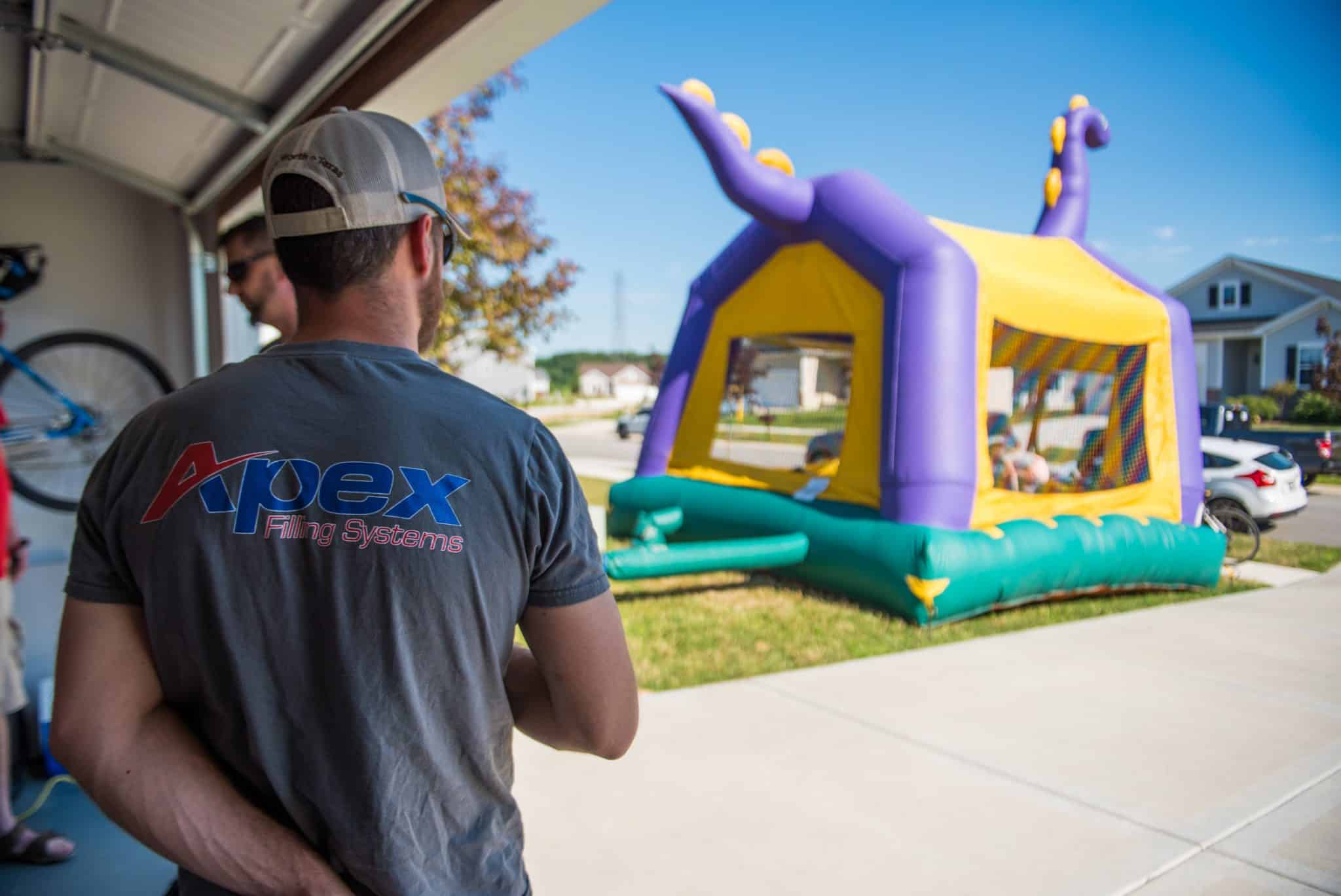 Apex employee and a bouncy house in the distance