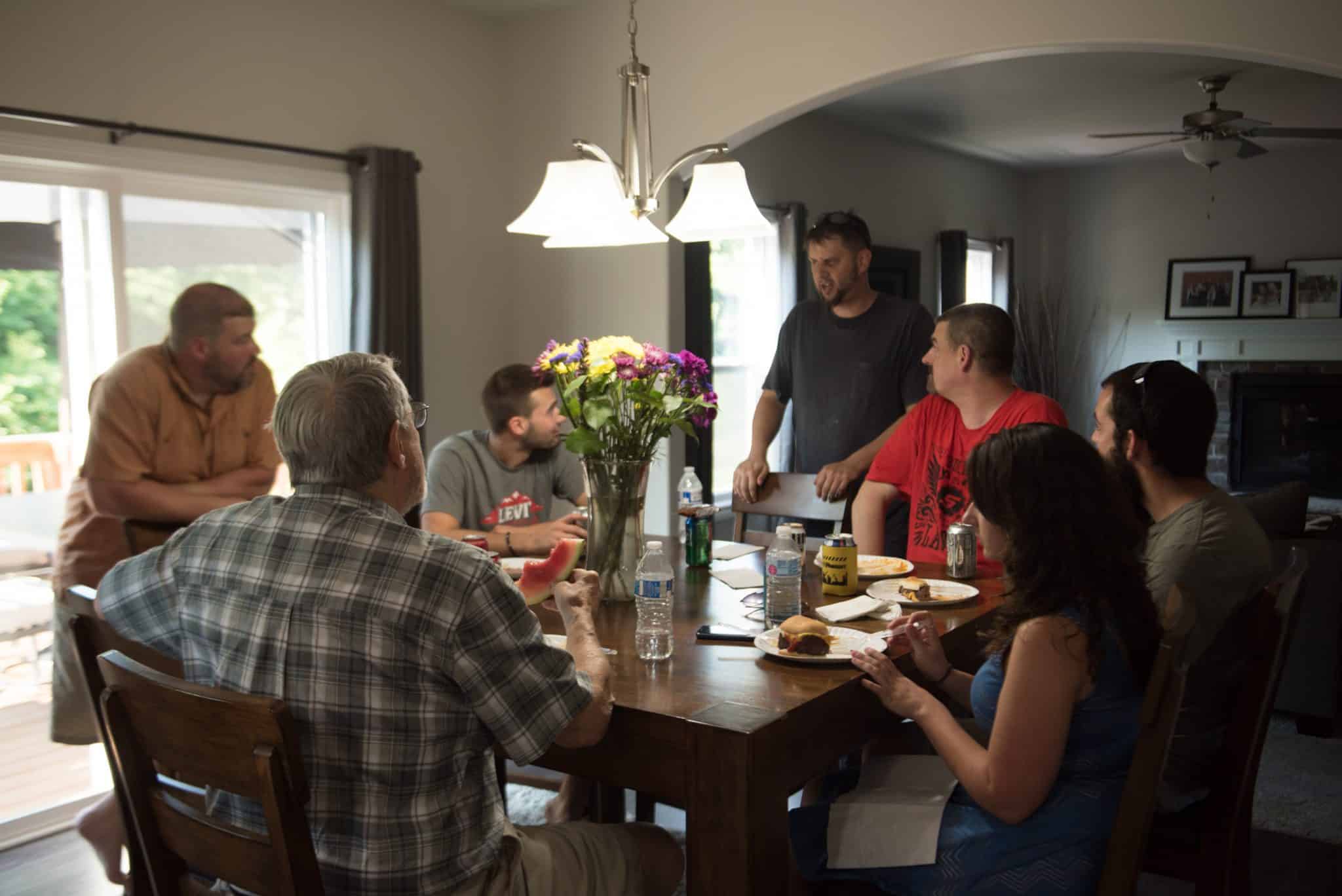 Apex employees and family members chatting at a dinner table