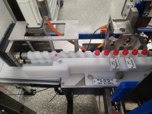 Vials with Caps are moving through a line